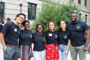 Community at Cornell IDP Alumni Facilitators in 2019 stand with their arms around each other and in matching IDP t-shirts; From left to right: Dylan VanDuyne '18, Alicia O'Neal '18, Alexis Wilson '19, Sarah Aiken '18, Maya Portillo '17, Baba Adejuyigbe '18